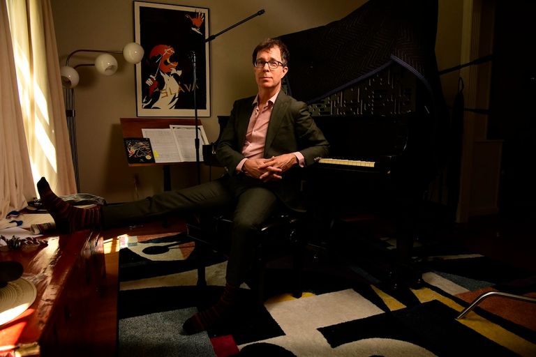 Singer-songwriter Ben Folds sitting at a grand piano in a suit for a promotional portrait.